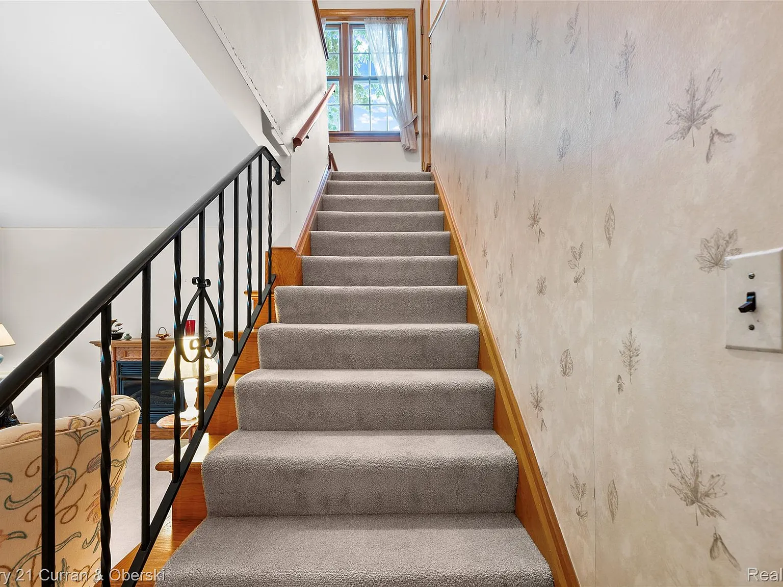 Carpeted staircase to upper level